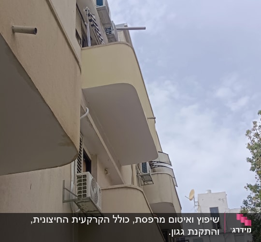 קירות מתקלפים במרפסת בניין עם מזגנים
